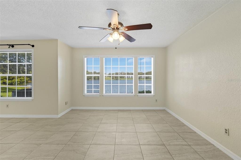 1039 South Hiawassee Road, Unit 2918 Orlando, FL 32835 - Photo 6 of 28 an empty room with chandelier fan and windows