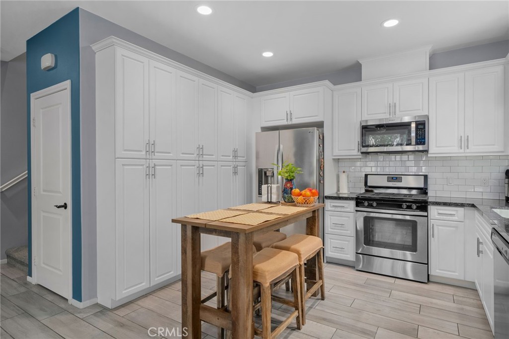 4171 South Cardinale Privado, Unit 2 Ontario, CA 91761 - Photo 9 of 30 a kitchen with stainless steel appliances a stove a sink refrigerator and a refrigerator with wooden floor