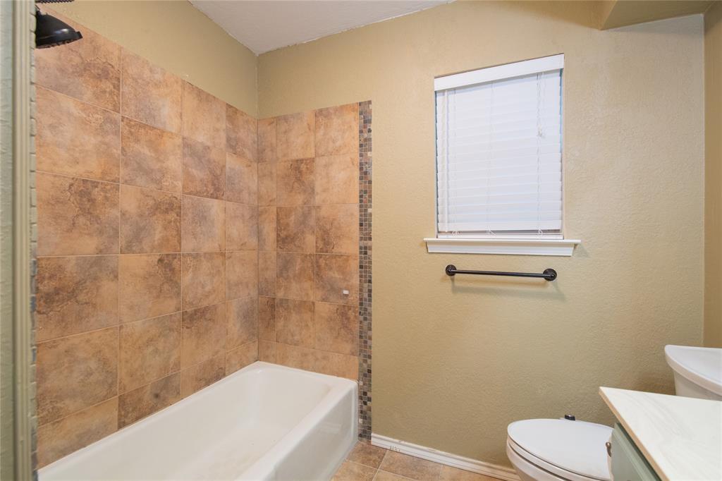 905 Martha Lane Azle, TX 76020 - Photo 11 of 18 Bathroom with vanity, shower / bath combination, a textured wall, and tile patterned flooring