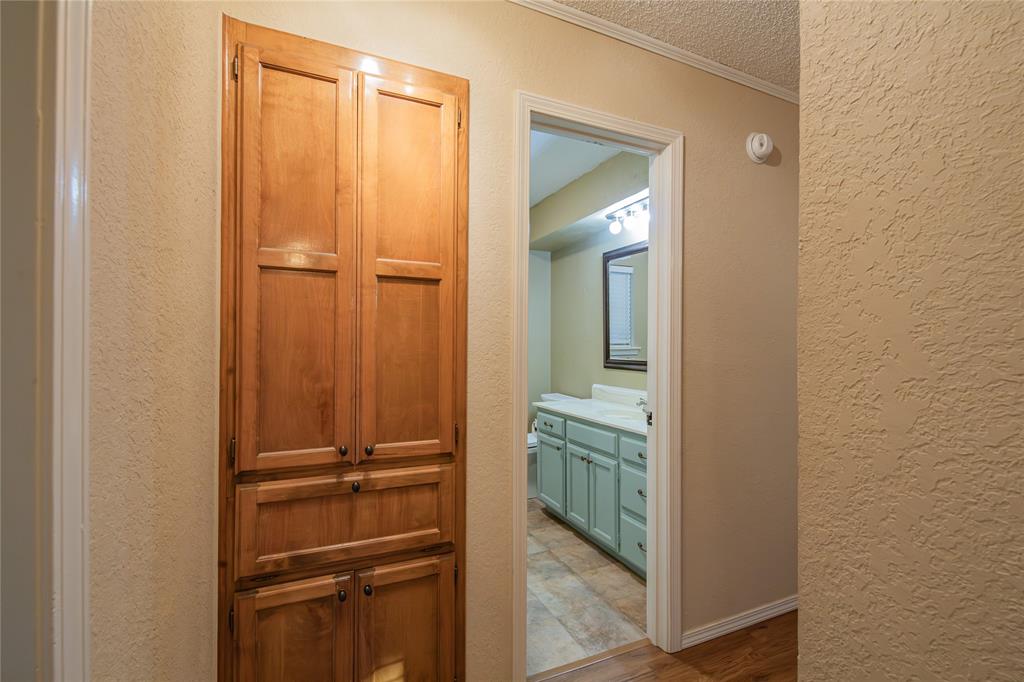 905 Martha Lane Azle, TX 76020 - Photo 13 of 18 Corridor with a textured wall, crown molding, a textured ceiling, and dark wood-type flooring