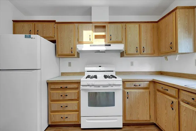a kitchen with cabinets appliances a sink and a window