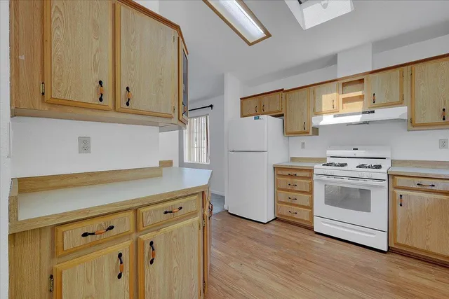 a kitchen with white cabinets and white appliances