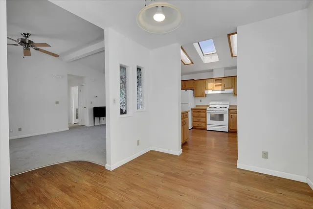 a view of a kitchen with wooden floor and a refrigerator