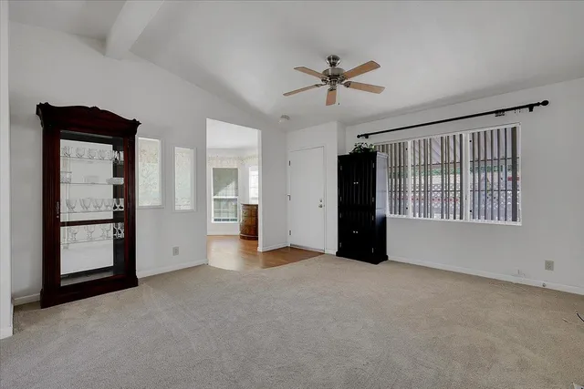 a view of an empty room with window and closet area