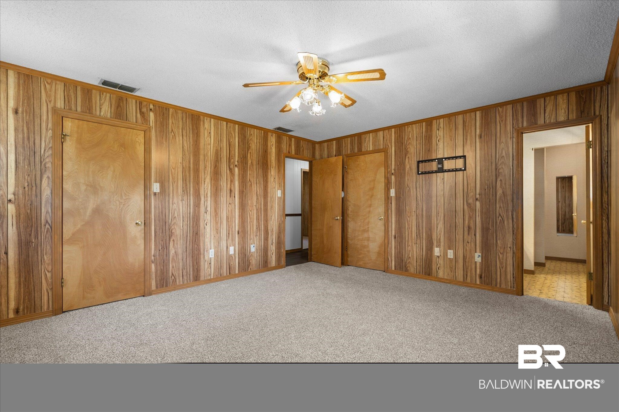 5503 Darring Street Satsuma, AL 36572 - Photo 15 of 31 Unfurnished bedroom featuring wood walls, carpet, ornamental molding, ceiling fan, and a textured ceiling