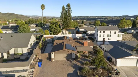 an aerial view of residential houses with city view and tree