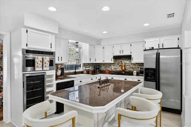 a kitchen with a sink stainless steel appliances and white cabinets