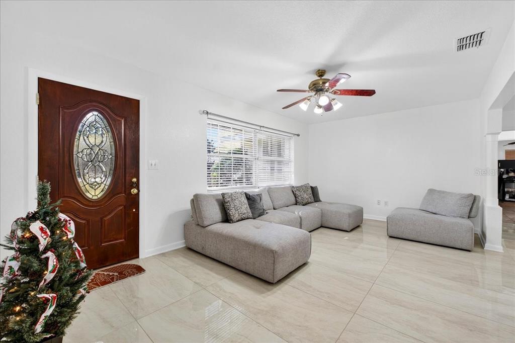 1501 North Combee Road Lakeland, FL 33801 - Photo 6 of 34 a living room with furniture a clock and a ceiling fan