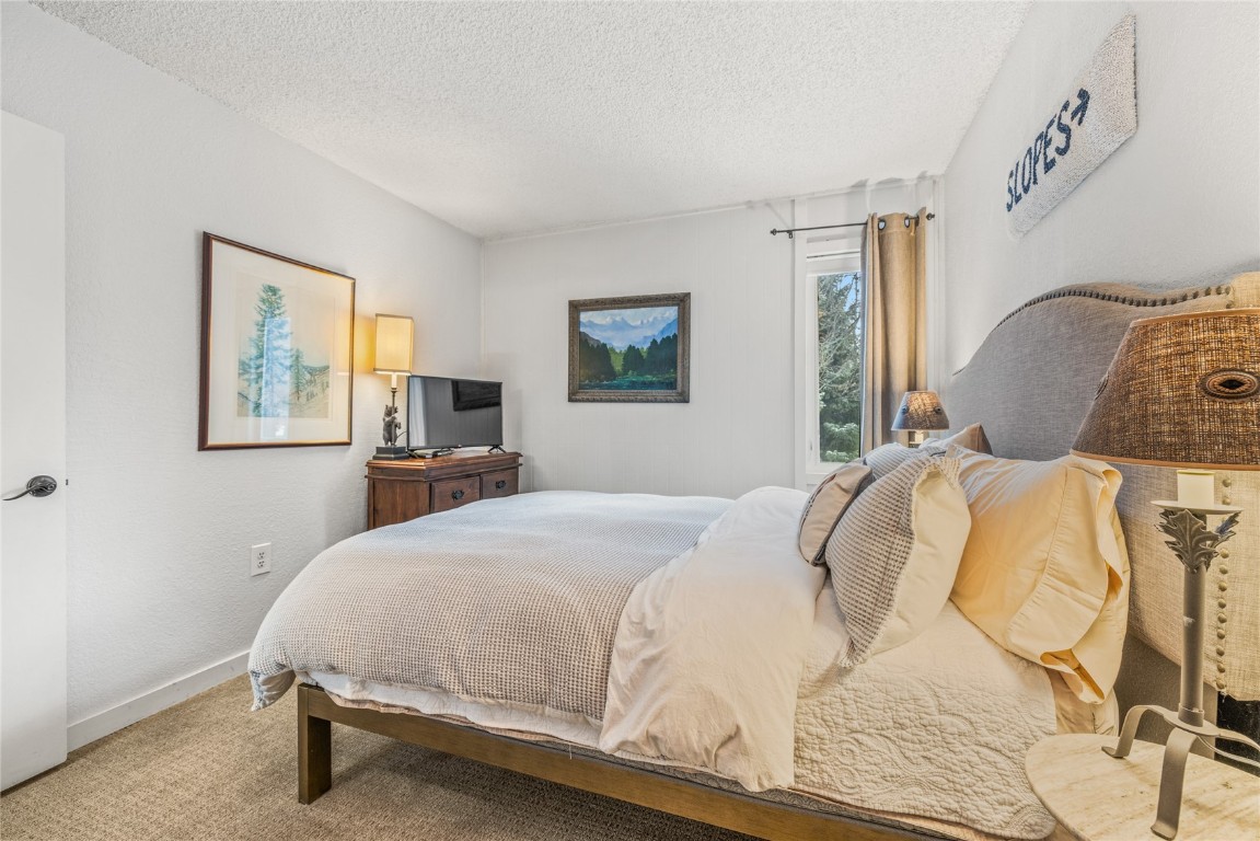 1179 Ski Hill Road, Unit 147 Breckenridge, CO 80424 - Photo 16 of 43 a bedroom with a bed and wooden floor