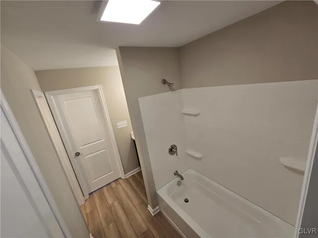 a bathroom with a tub a sink and a shower