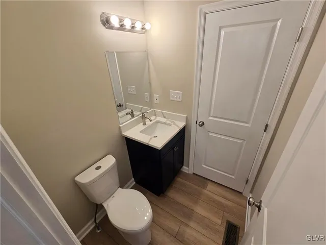a bathroom with a sink vanity mirror and toilet
