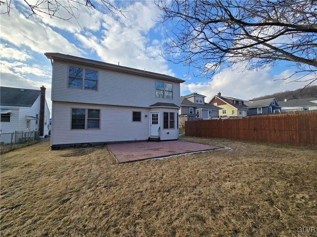 a view of a yard in front of a house with large tree