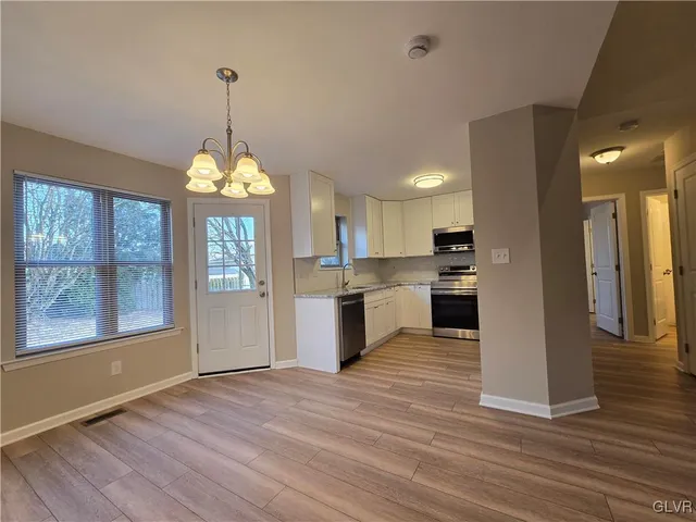 a view of a kitchen with granite countertop stainless steel appliances and wooden floor