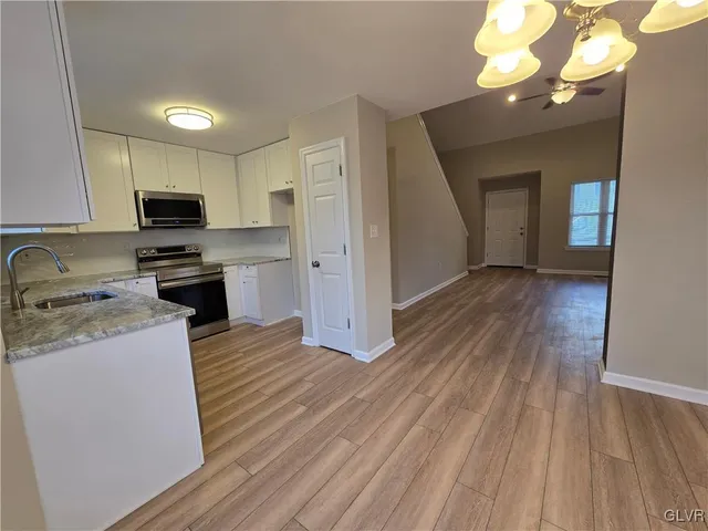 a kitchen with cabinets and wooden floor