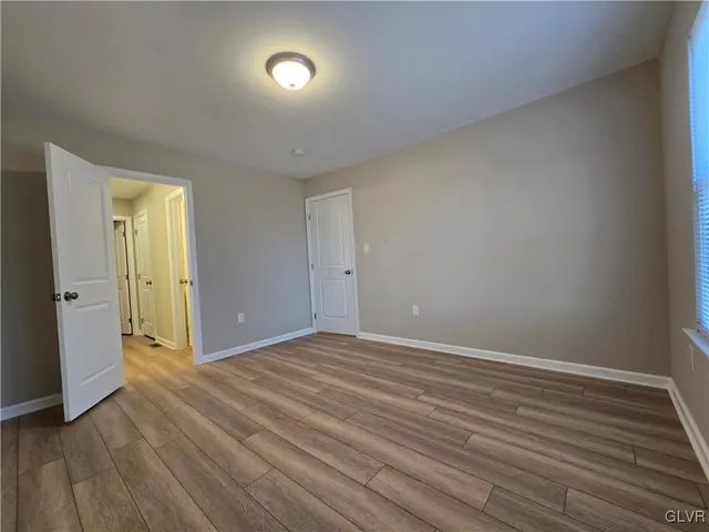 a view of an empty room with wooden floor