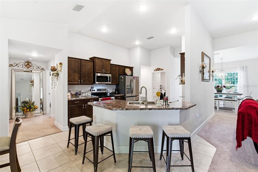 12181 Topaz Street Spring Hill, FL 34608 - Photo 21 of 71 a kitchen with stainless steel appliances kitchen island granite countertop a dining table and chairs