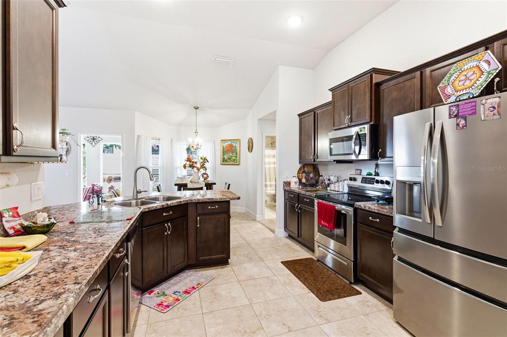12181 Topaz Street Spring Hill, FL 34608 - Photo 24 of 71 a kitchen with stainless steel appliances granite countertop a sink stove and refrigerator