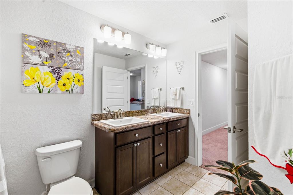 12181 Topaz Street Spring Hill, FL 34608 - Photo 31 of 71 a bathroom with a granite countertop toilet sink and mirror