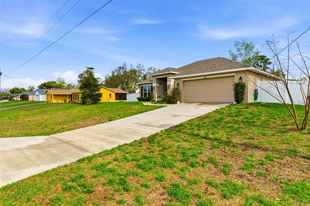 12181 Topaz Street Spring Hill, FL 34608 - Photo 4 of 71 a front view of a house with a yard