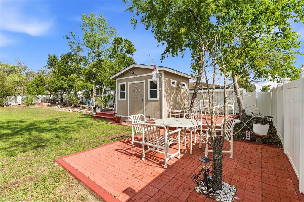 12181 Topaz Street Spring Hill, FL 34608 - Photo 47 of 71 a view of a patio with table and chairs potted plants and large tree