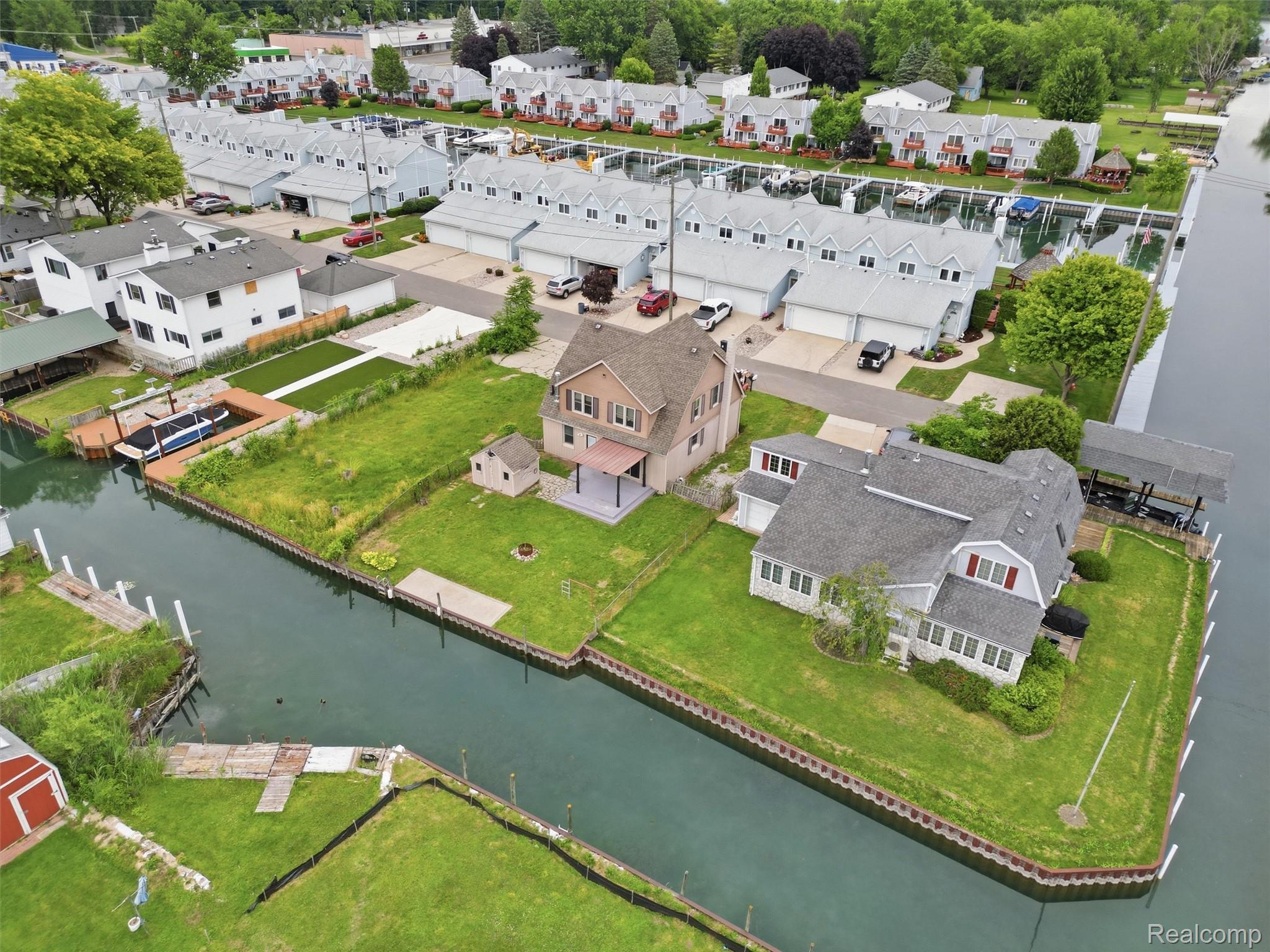 117 Kenyon Road Algonac, MI 48001 - Photo 13 of 47 Waterfront property featuring a private boat hoist, covered patio, and lush green lawn