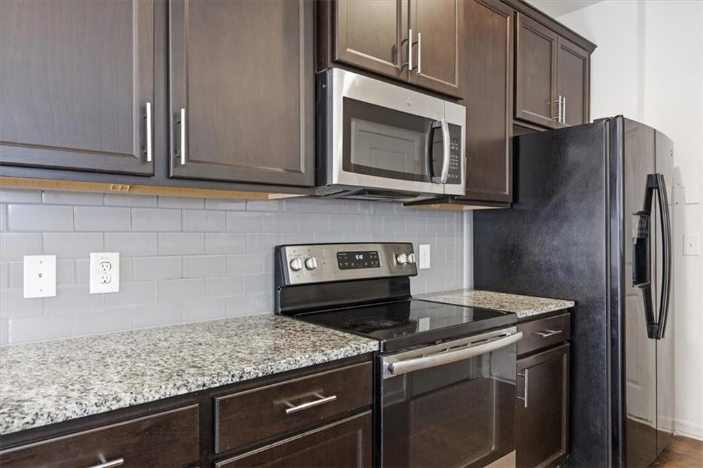 5064 Longview Walk Decatur, GA 30035 - Photo 16 of 30 a kitchen with granite countertop a sink stainless steel appliances and cabinets