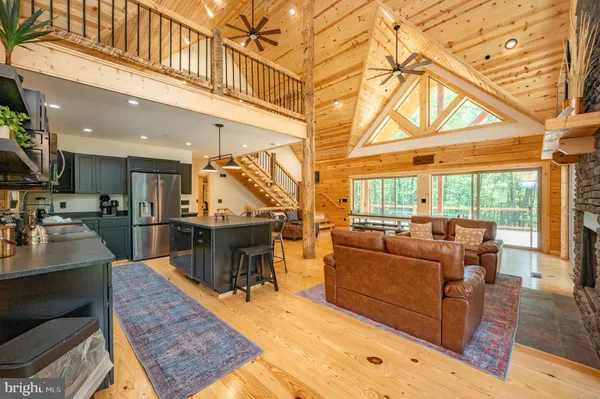 a kitchen with stainless steel appliances granite countertop a stove a refrigerator a sink a dining table and chairs with the ocean view