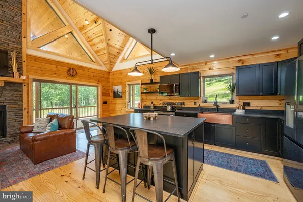 a kitchen with stainless steel appliances granite countertop a sink refrigerator stove and microwave