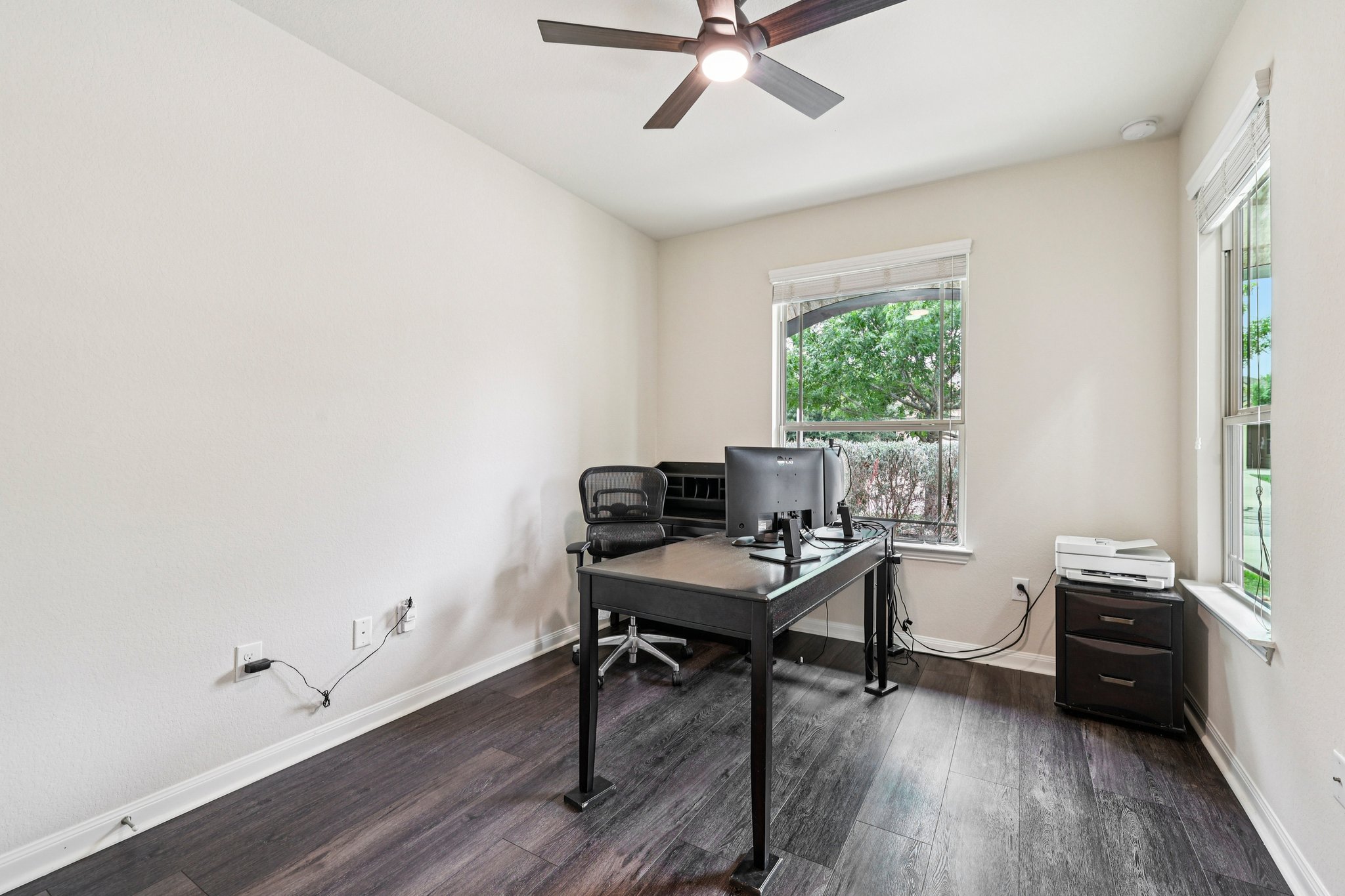10033 Gertrudis Loop Austin, TX 78747 - Photo 12 of 39 This room features dark-toned flooring, light-colored walls, and a ceiling fan with integrated lighting