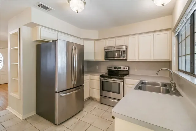 a kitchen with stainless steel appliances granite countertop a refrigerator sink and stove
