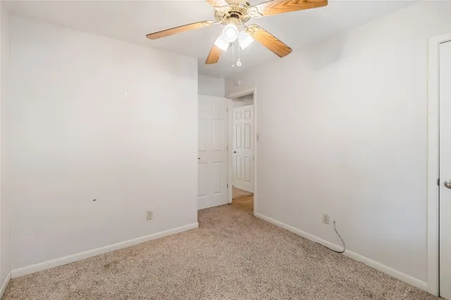 an empty room with a fan and a fan