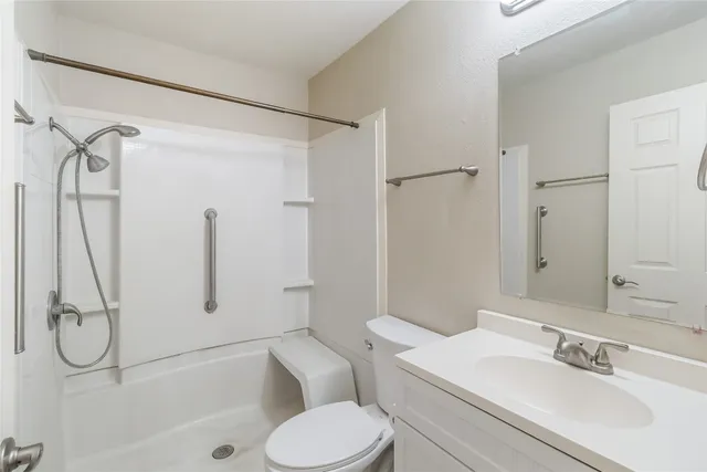 a bathroom with a granite countertop sink toilet and shower