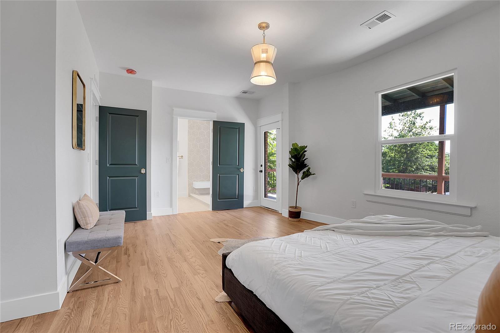 1260 Garfield Street Denver, CO 80206 - Photo 13 of 24 a bedroom with a bed and a chandelier