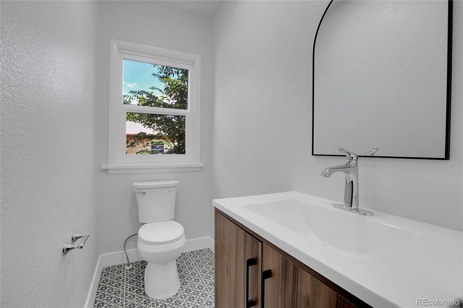 1260 Garfield Street Denver, CO 80206 - Photo 8 of 24 a bathroom with a toilet sink and mirror