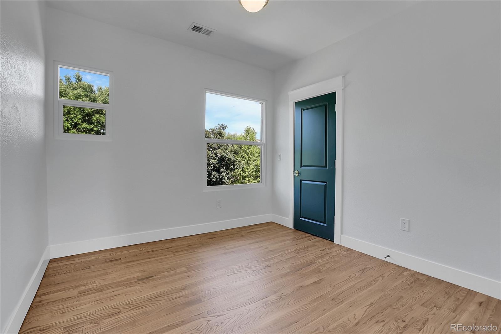 1260 Garfield Street Denver, CO 80206 - Photo 9 of 24 an empty room with wooden floor and a window