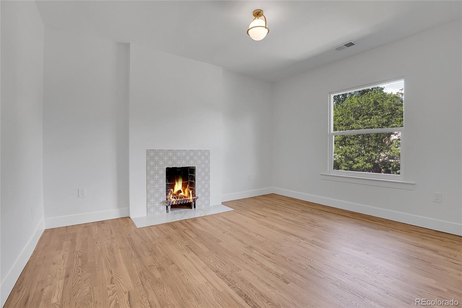 1260 Garfield Street Denver, CO 80206 - Photo 10 of 24 an empty room with a window and a fireplace