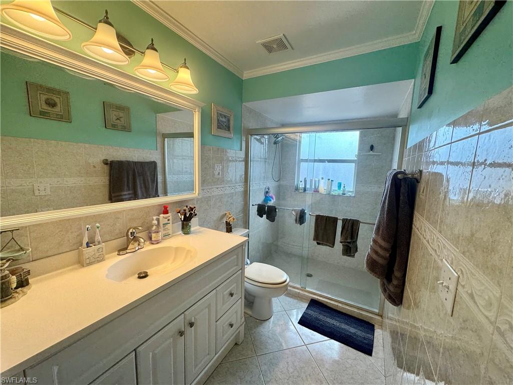 276 Madison Drive Naples, FL 34110 - Photo 11 of 22 a bathroom with a double vanity sink and mirror