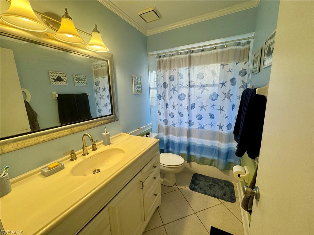 276 Madison Drive Naples, FL 34110 - Photo 14 of 22 a bathroom with a sink mirror toilet and shower