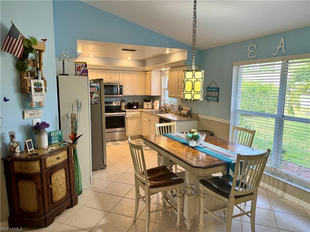276 Madison Drive Naples, FL 34110 - Photo 2 of 22 a dining room with furniture a chandelier and wooden floor