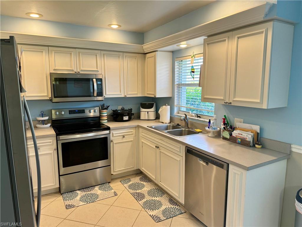 276 Madison Drive Naples, FL 34110 - Photo 3 of 22 a kitchen with a sink stove and microwave