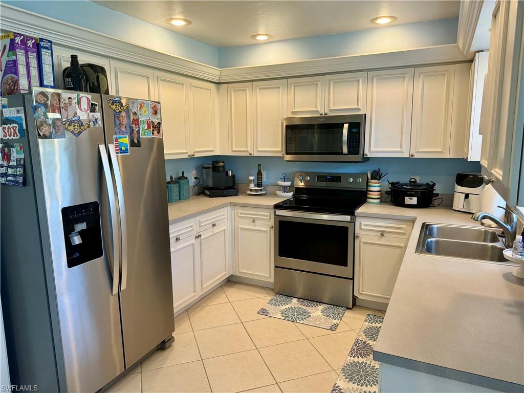 276 Madison Drive Naples, FL 34110 - Photo 4 of 22 a kitchen with stainless steel appliances granite countertop a refrigerator sink and cabinets