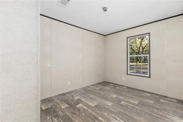 a view of a big room with wooden floor and windows