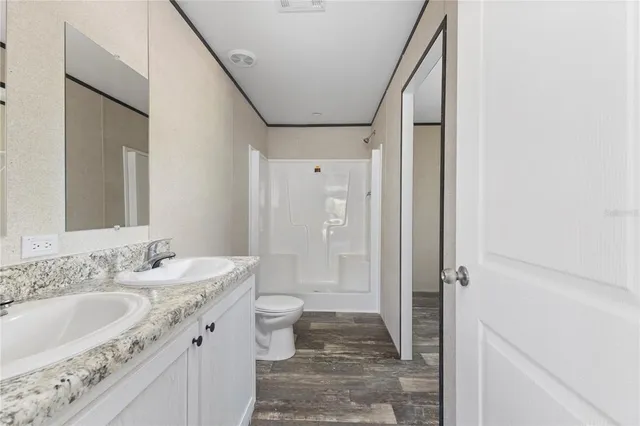 a bathroom with a granite countertop sink a toilet and shower