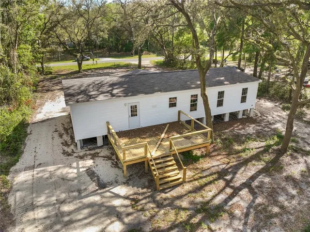 an aerial view of a house with a yard and trees