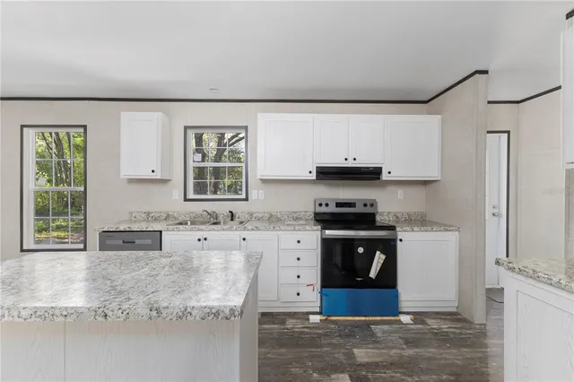 a kitchen with stainless steel appliances granite countertop a stove a sink and a granite counter tops