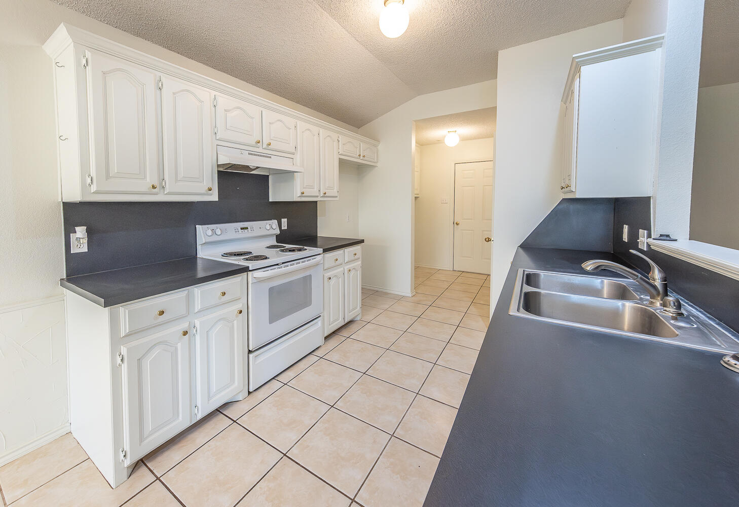 6109 13th Street Lubbock, TX 79416 - Photo 3 of 24 a kitchen with stainless steel appliances granite countertop a sink stove and cabinets
