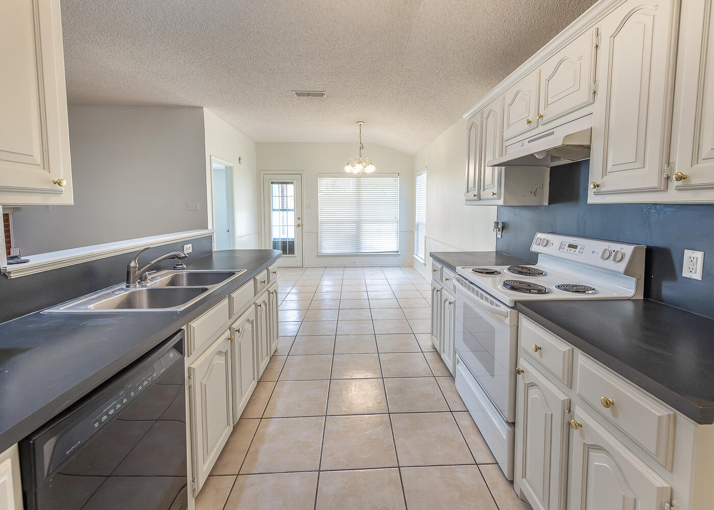 6109 13th Street Lubbock, TX 79416 - Photo 9 of 24 a kitchen with a sink stove and cabinets