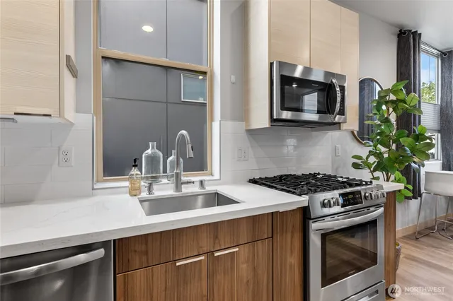 a kitchen with stainless steel appliances a sink stove and microwave