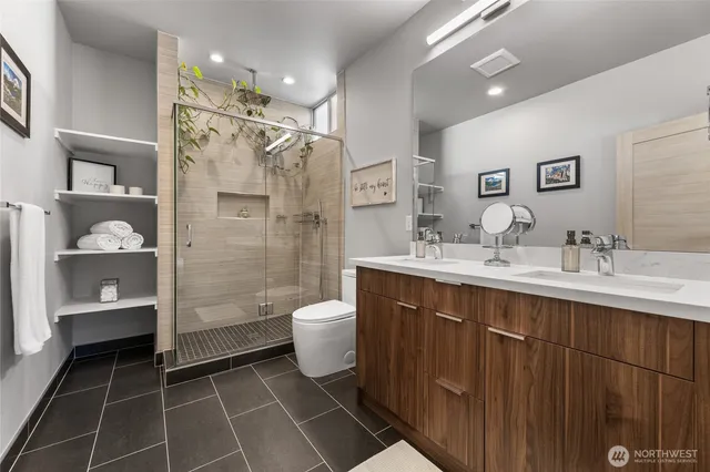 a bathroom with a double vanity sink mirror and toilet
