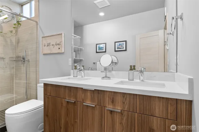 a bathroom with a double vanity sink toilet and a mirror
